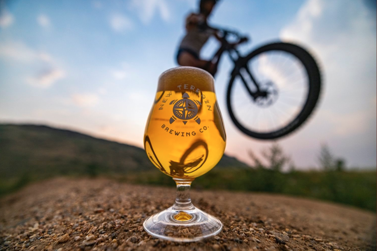 Photo of drink in front bicycle in back of Terrain Brewing Co.